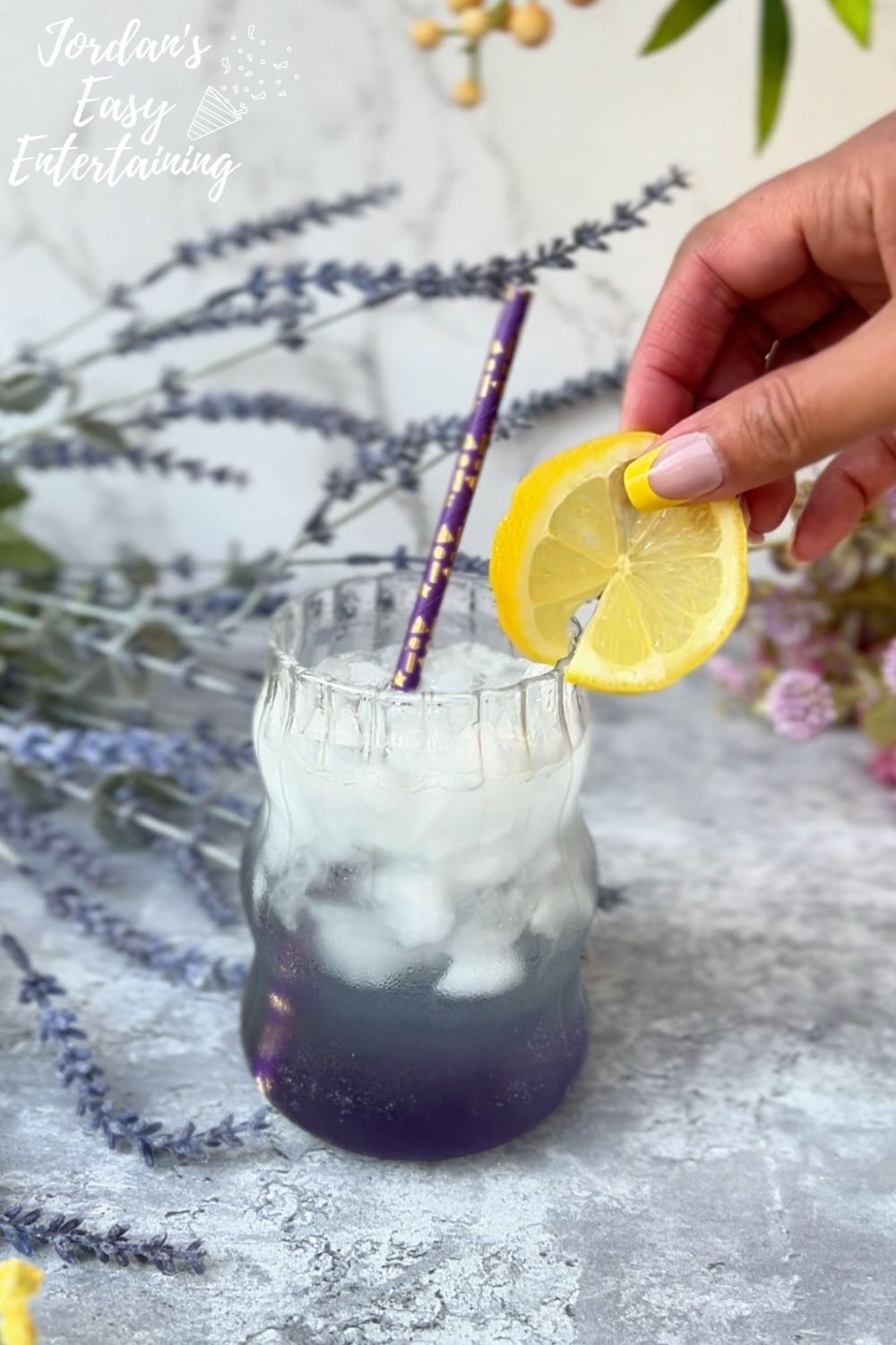 adding lemon slices as a garnish for a sparkling lavender lemonade mocktail