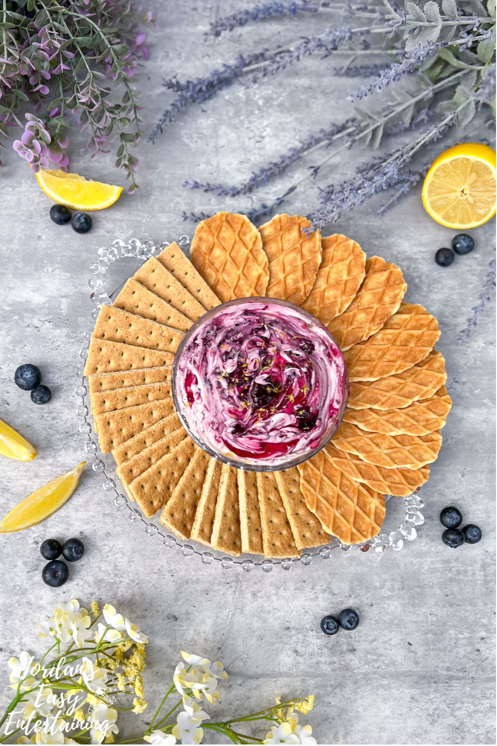 a blueberry cream cheese dessert dip served with graham crackers and butter wafer cookies