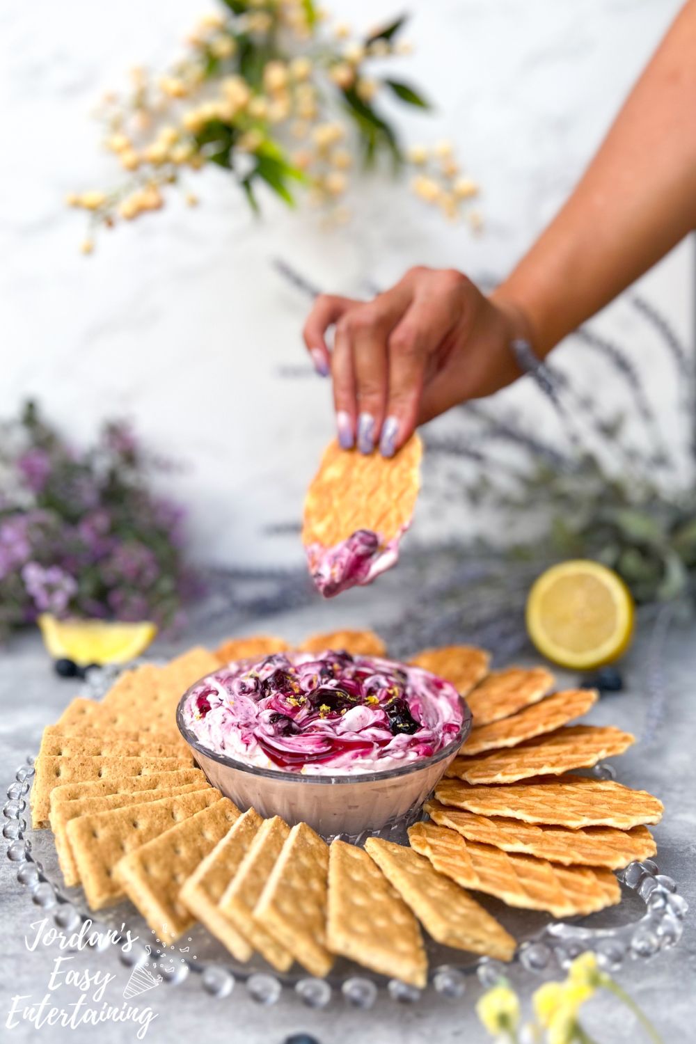 a wafer cookie after dunking into a velvety blueberry cheesecake dip
