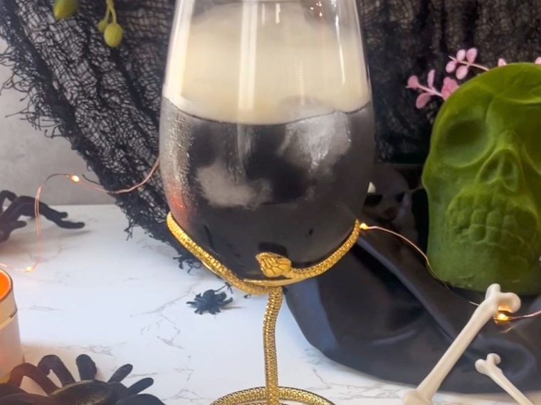 a smoked cocktail served in a snake glass for a Halloween party
